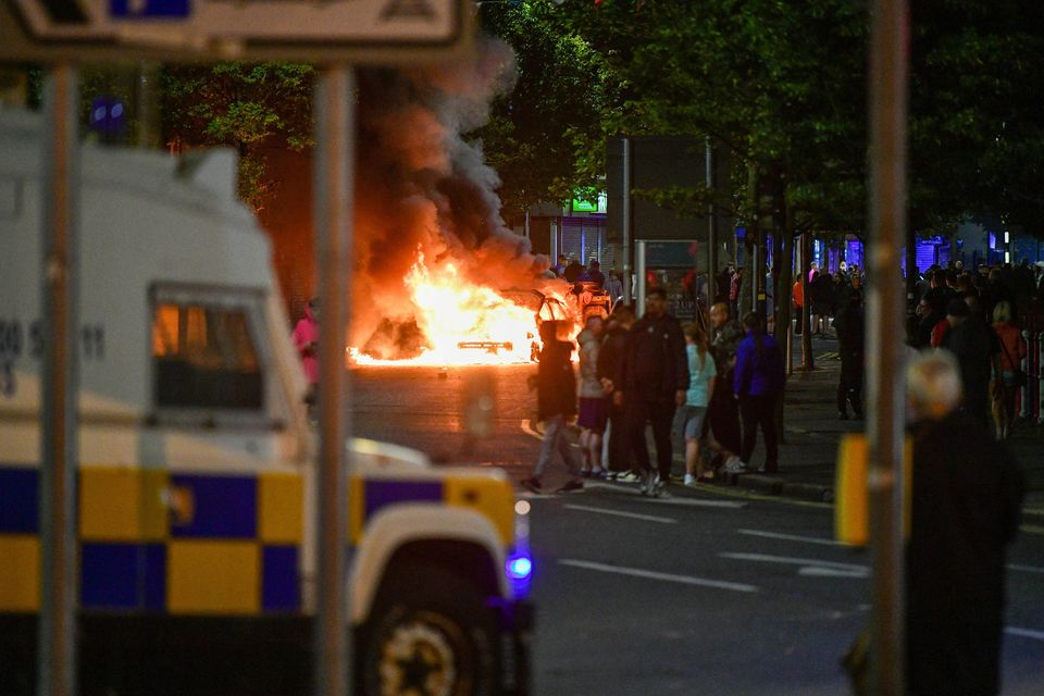 Police officers in Belfast face petrol bombs thrown by rioters during the second night of unrest, August 2024